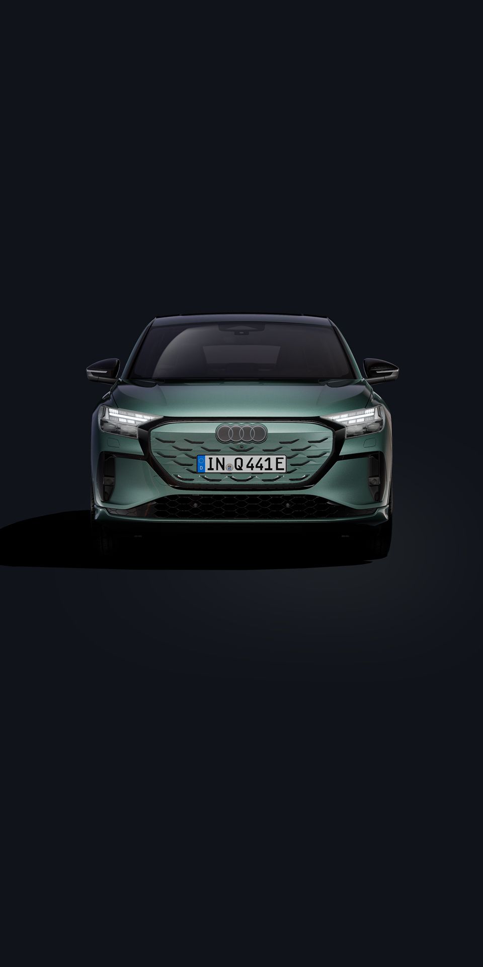 Der Q4 Sportback e-tron in Frontansicht auf dunklem Hintergrund stehend.