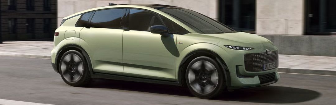 Der Audi A2 e-tron schräg von der Seite auf einer Straße in urbaner Umgebung.